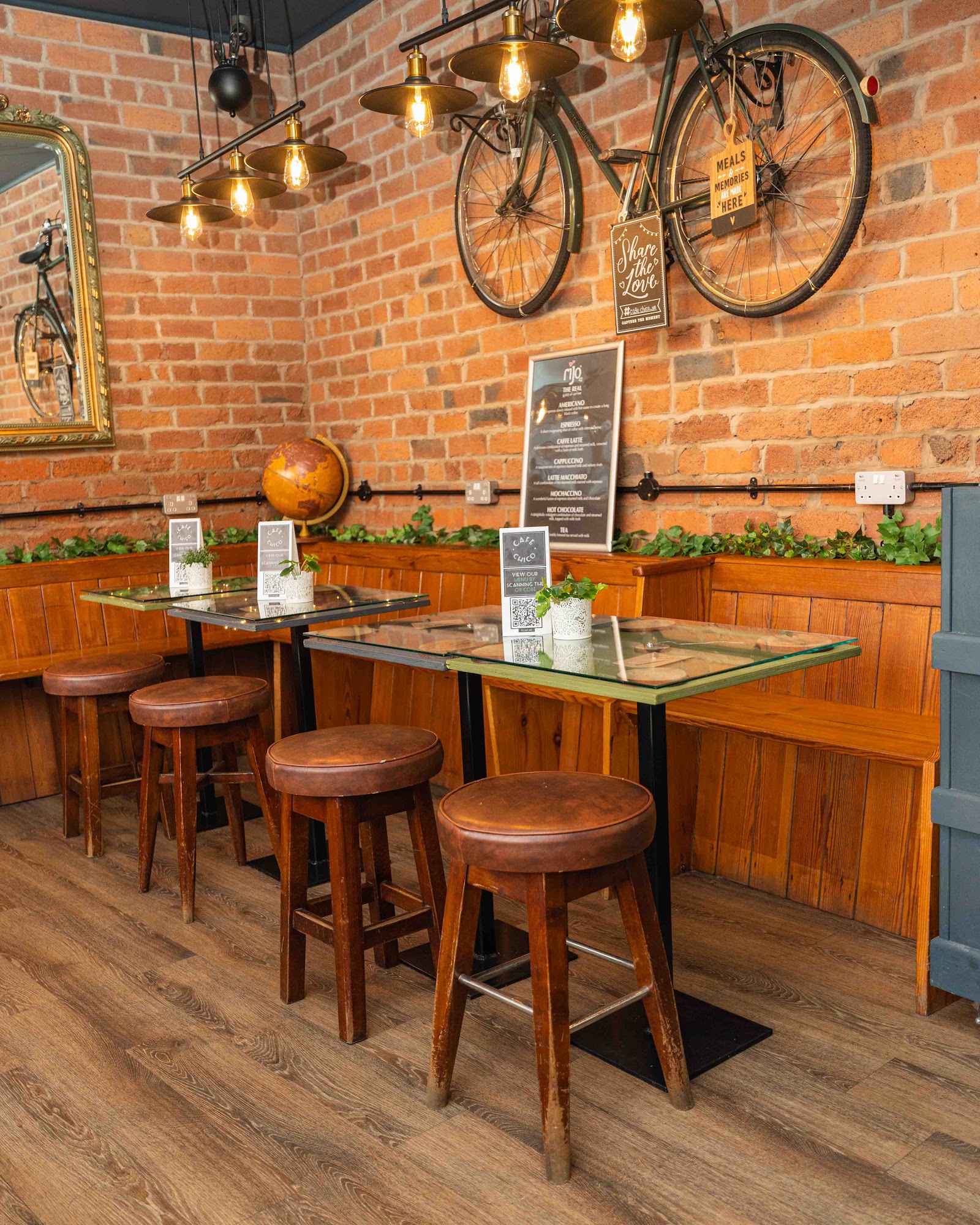 Inside Café Chico — exposed brick wall, vintage bicycle and warm Edison-bulb lighting